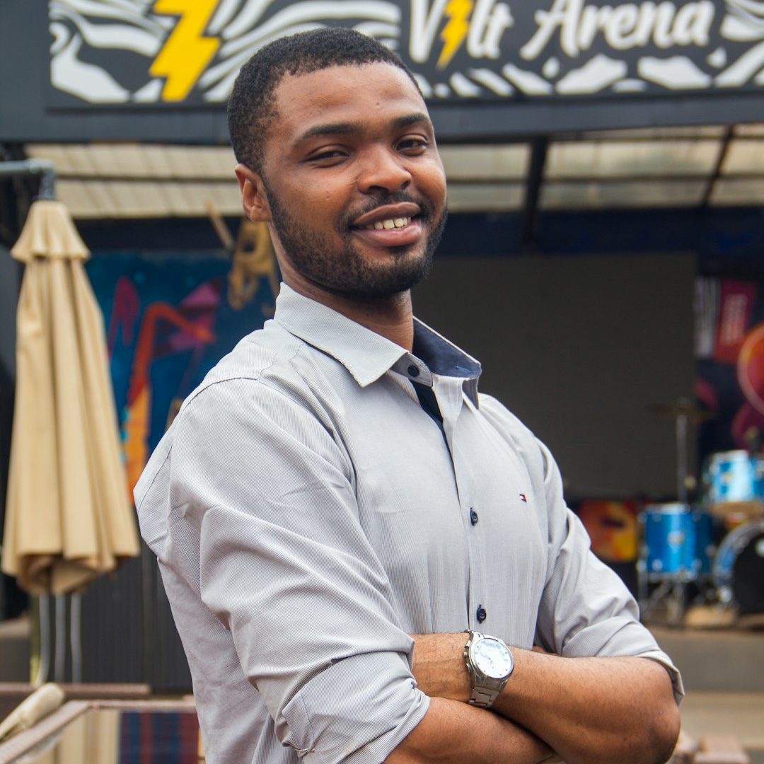 Photo by Blessing Olarewaju A man standing in front of a store with his arms crossed